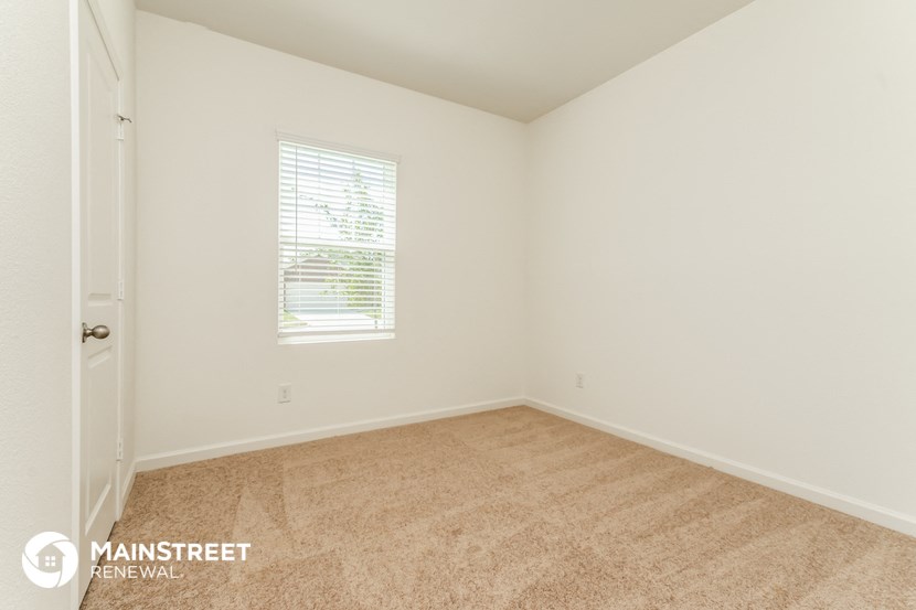 the upstairs bedroom with carpeted flooring and a window