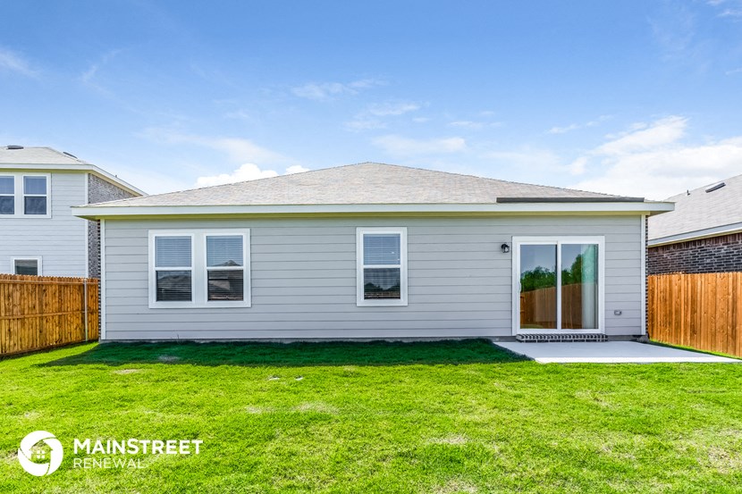 a small white house with a lawn in front of it