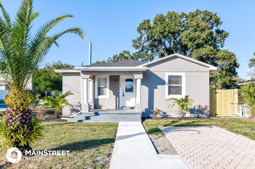 a small house with a palm tree in front of it