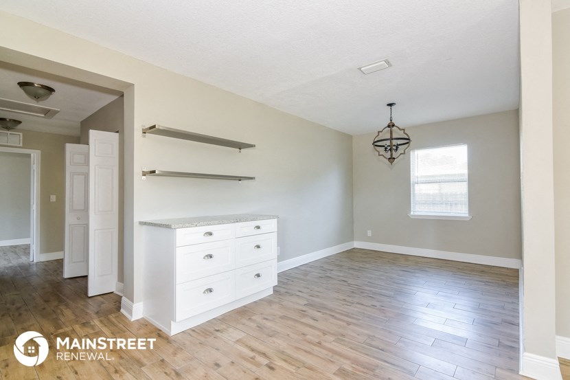 the master bedroom after the remodel with white cabinets and wood floors