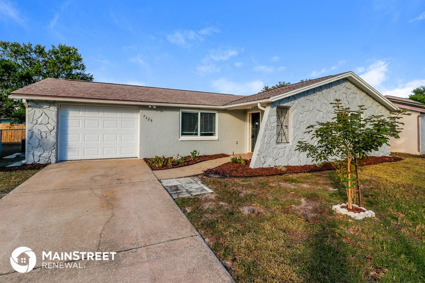a white house with a driveway and a white garage door