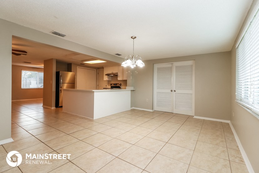 a kitchen and dining room with tile flooring and a large window