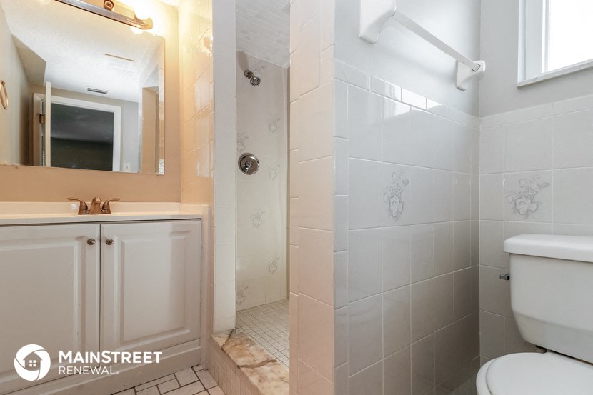 a bathroom with a toilet and a sink and a shower