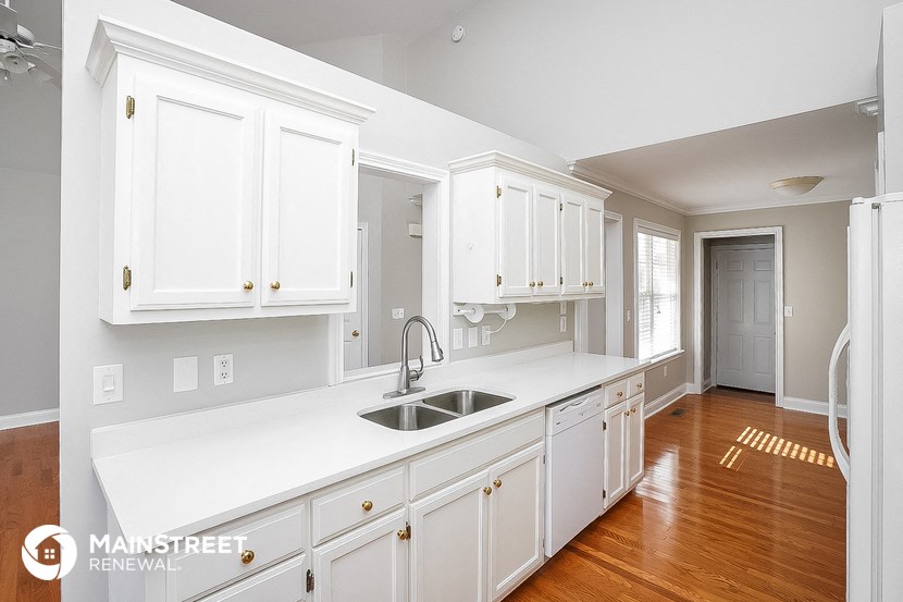 a large white kitchen with a sink and white cabinets