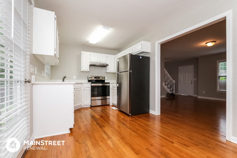 a renovated kitchen with white cabinets and stainless steel appliances