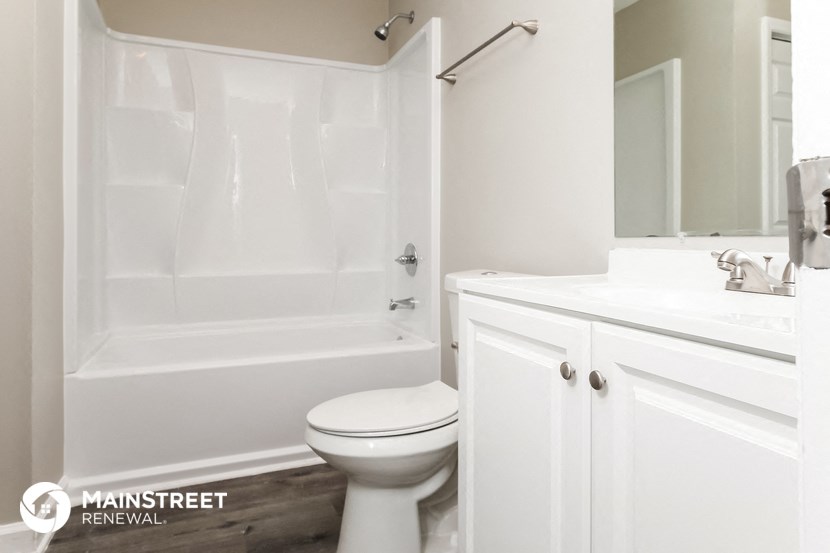 a bathroom with a toilet and a tub and a sink