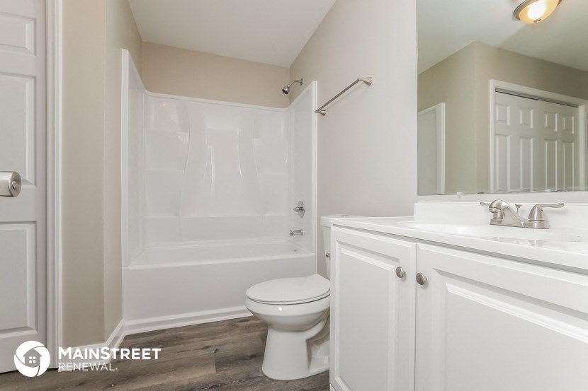 a bathroom with a toilet and a tub and a sink