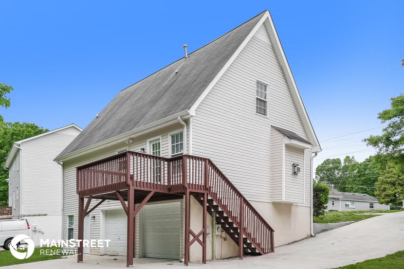the outside of a white church with a red balcony