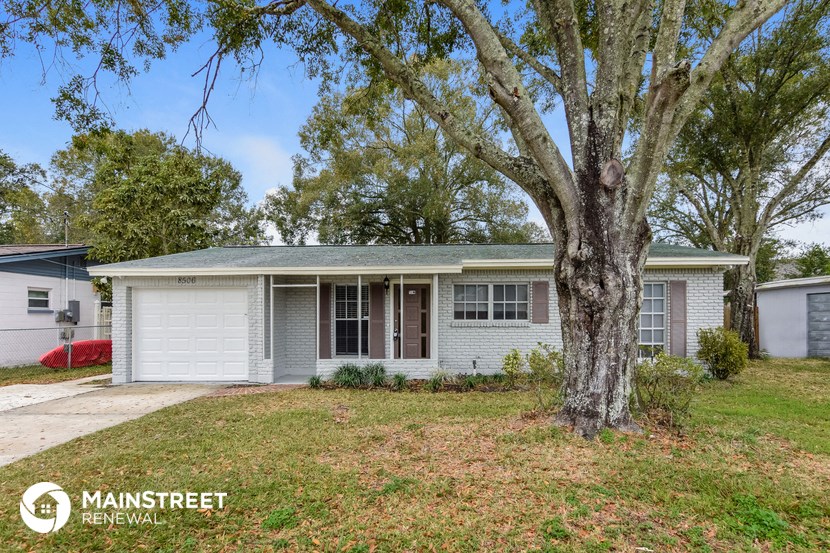 a small white house with a tree in front of it