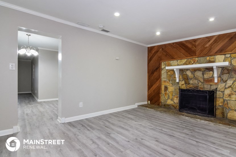 a living room with a fireplace and a wood floor