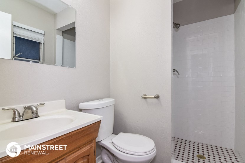 a bathroom with a toilet and a sink and a mirror