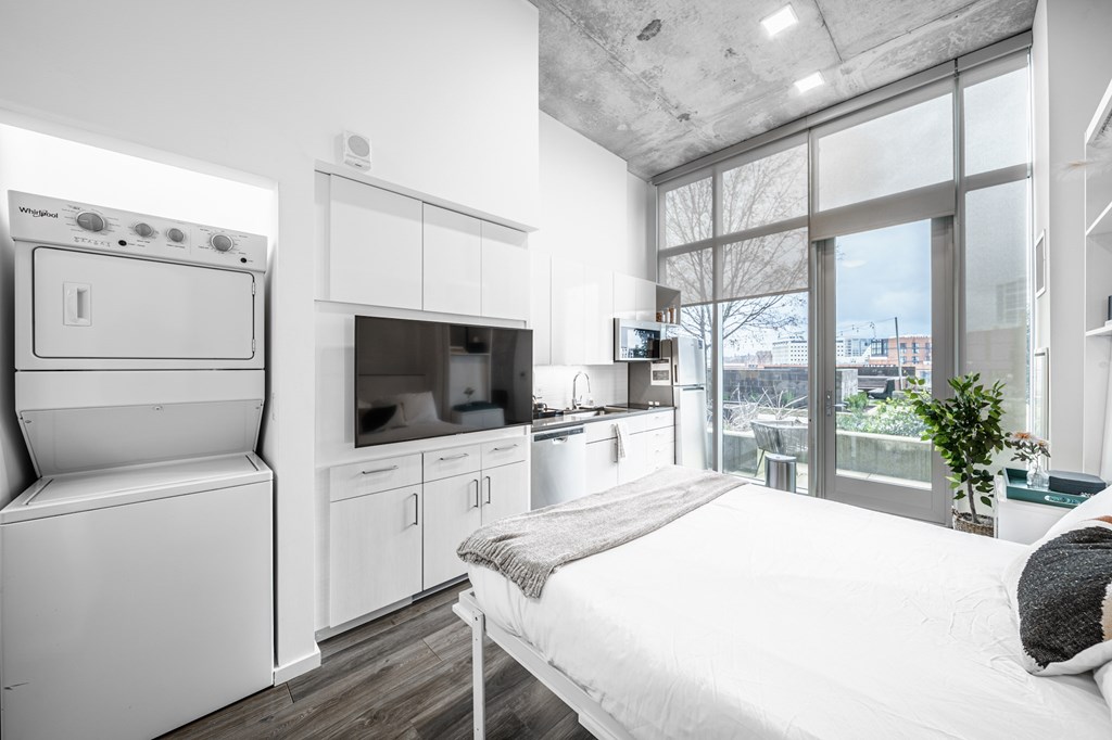 A person is sitting on a bed in a modern kitchen.