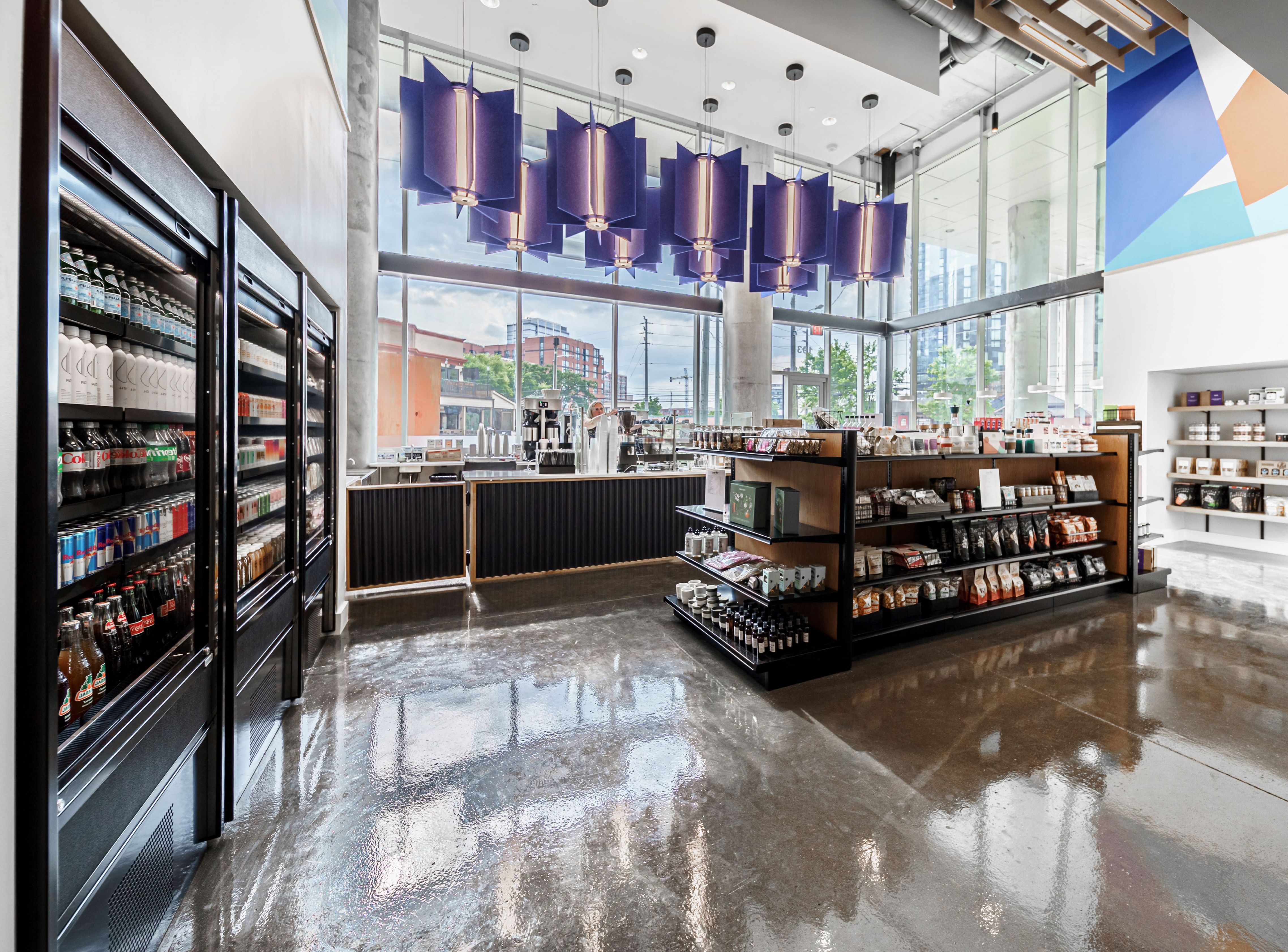 a grocery store with a large window and a counter with bottles of food and drinks