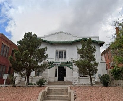 A white building with a green roof and a sign that says "Casa de la Cultura".