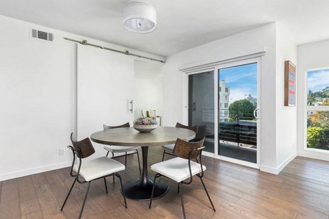 A dining room with a round table and chairs.