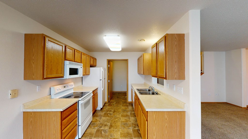 a kitchen with white appliances and wooden cabinets