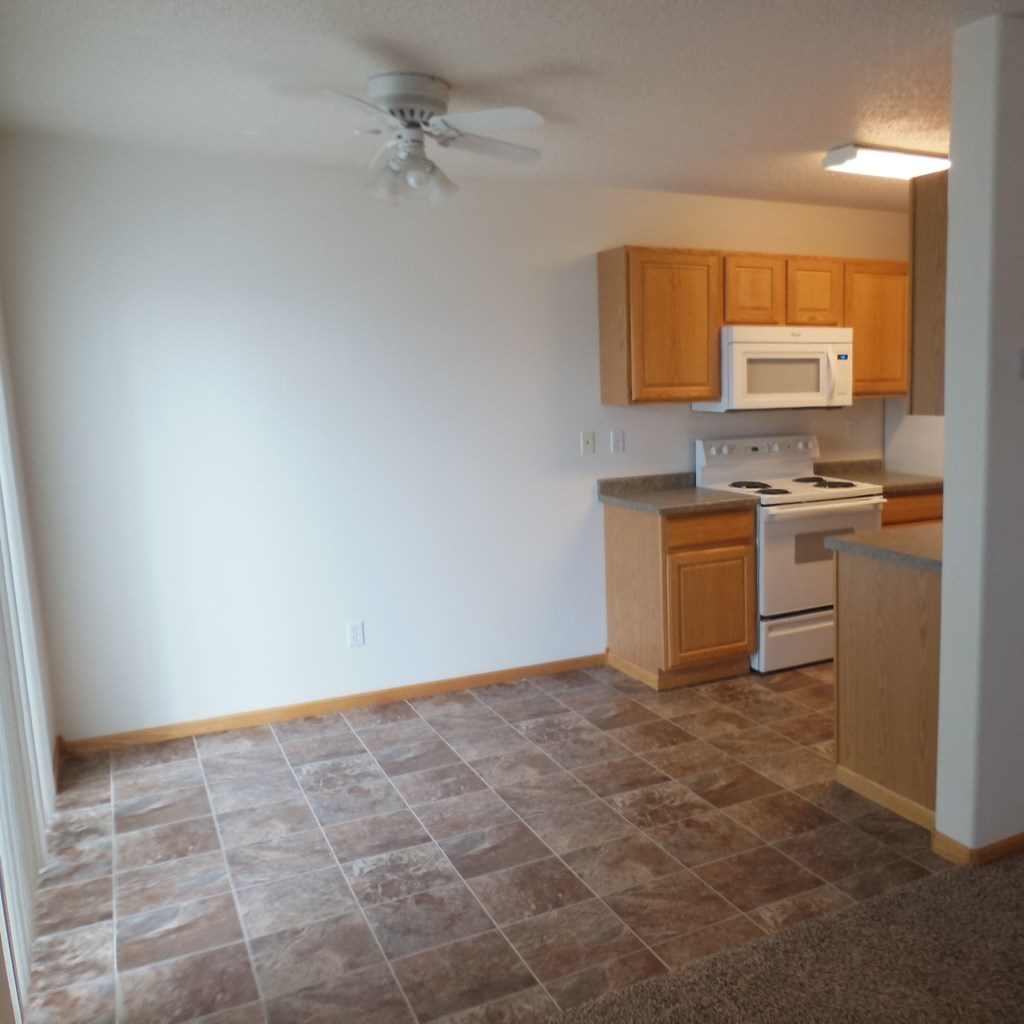kitchen, dining an empty kitchen with a ceiling fan and wooden cabinets