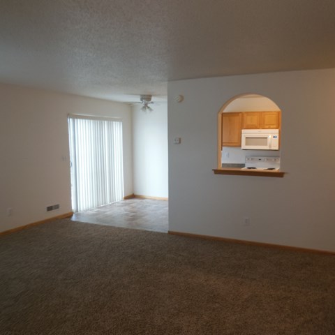 a view of a living room and a kitchen with a window