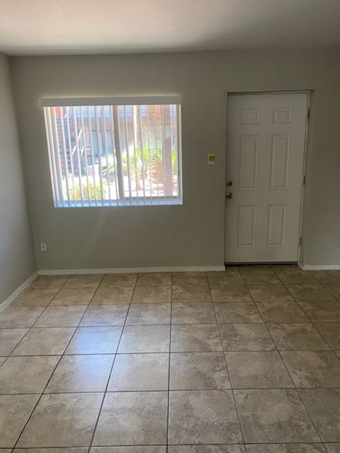 an empty living room with a window and a door