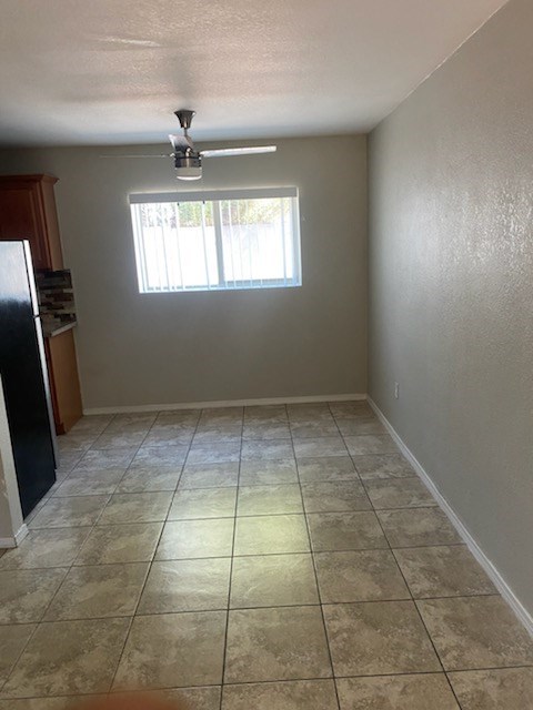 an empty room with a ceiling fan and a window