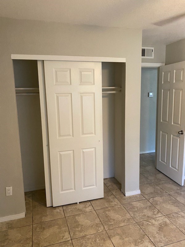 an empty room with a closet and two doors