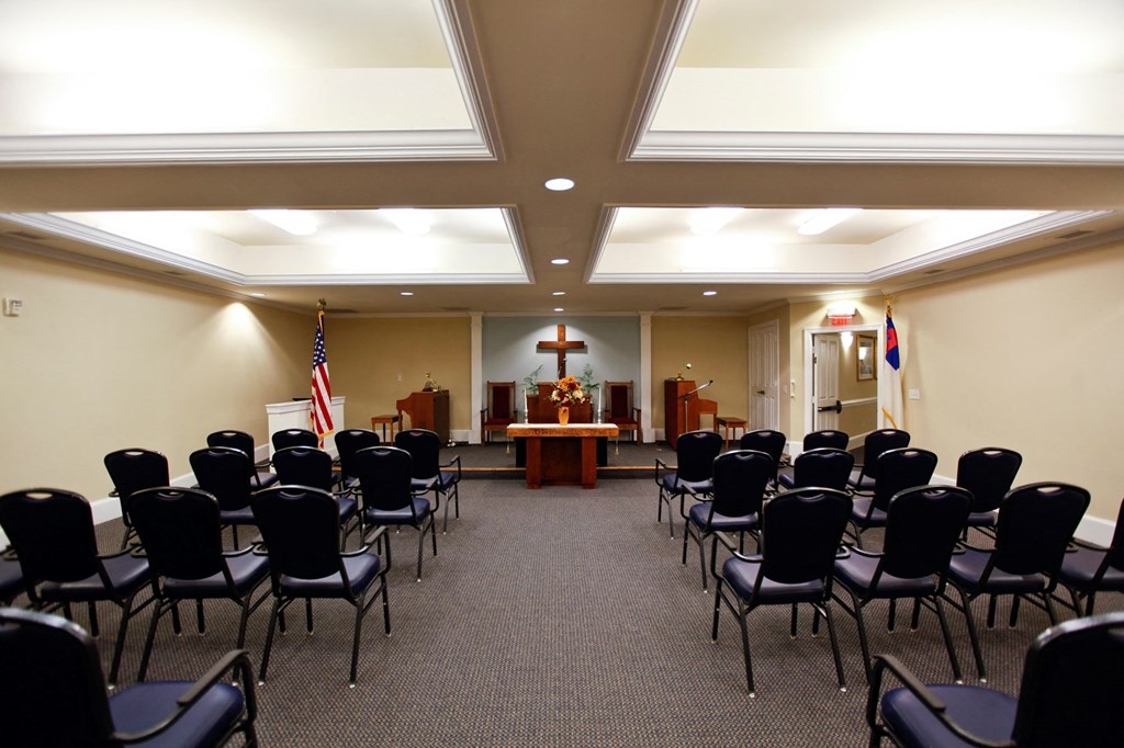 a conference room with rows of chairs and a podium in the center of the room