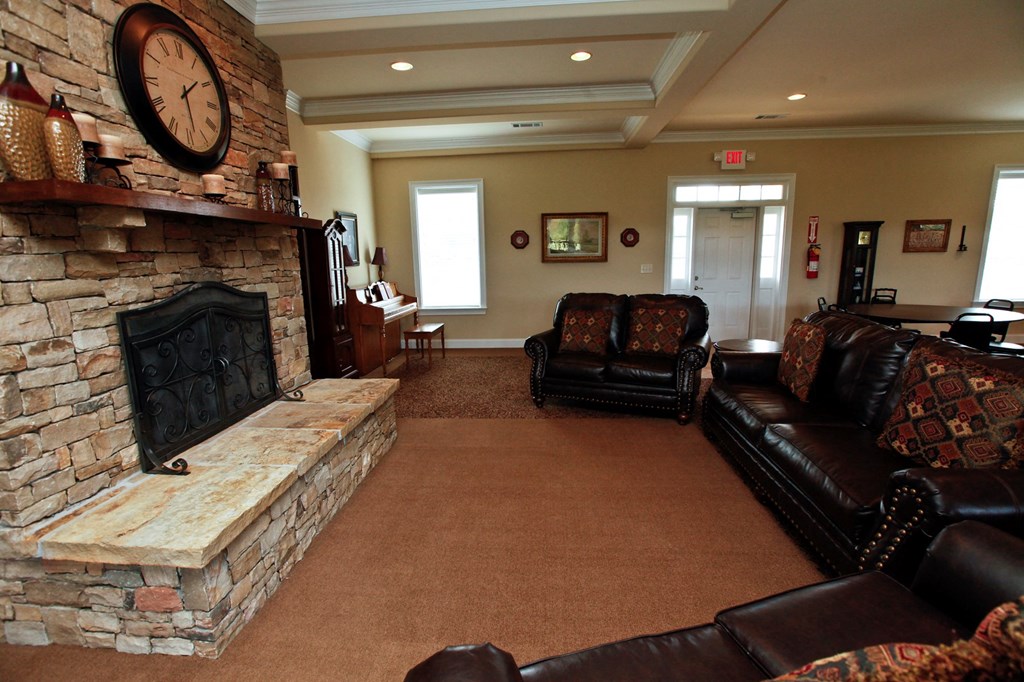 a living room with a fireplace and leather furniture