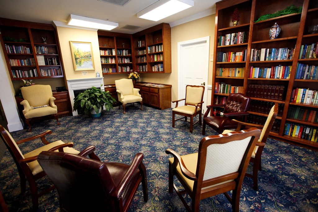 a reading room with chairs and bookshelves in a library