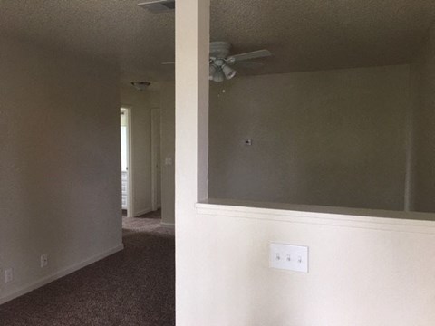 a living room with a ceiling fan and a mirror