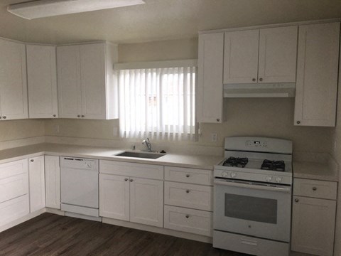 a kitchen with white cabinets and a stove and a sink