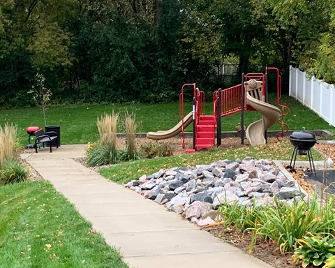 a playground in a park next to a sidewalk