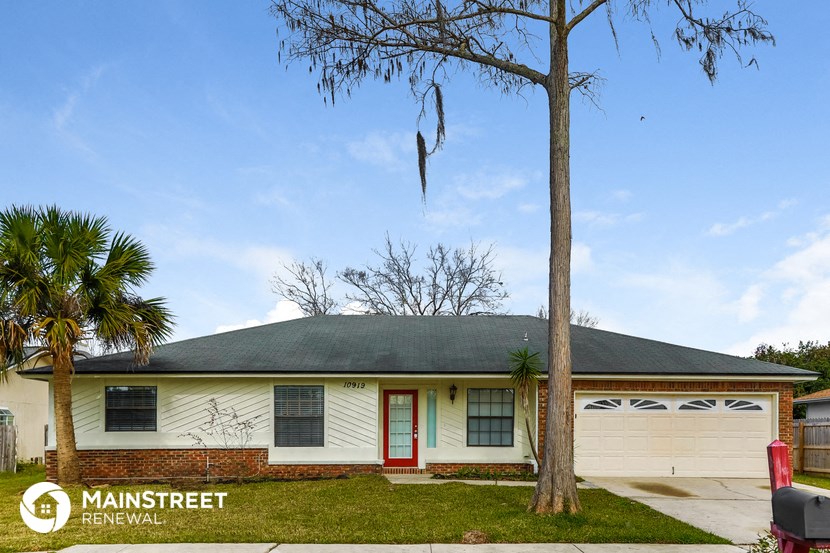 the front of a white house with a palm tree