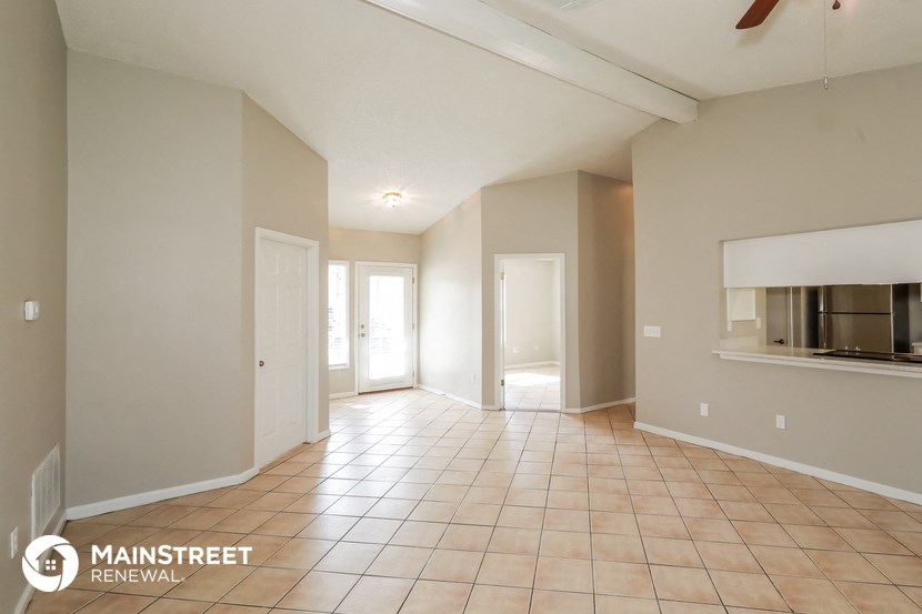 a spacious living room with tile flooring and a fireplace