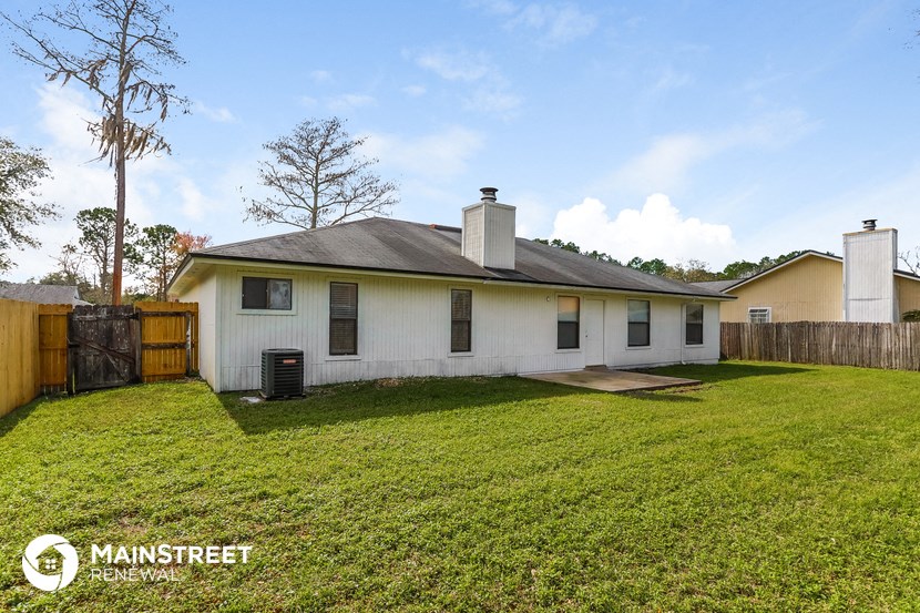 a white house with a yard and a wooden fence