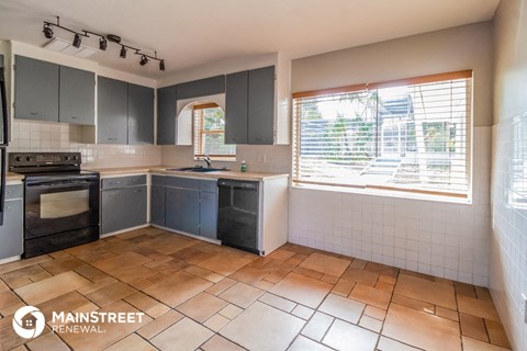 a kitchen with a stove sink and a window
