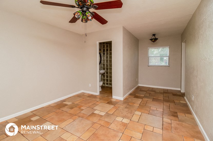 a living room with a ceiling fan and tile floors
