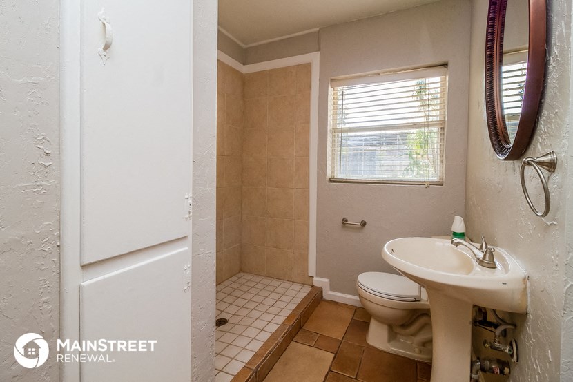 a bathroom with a sink toilet and a window