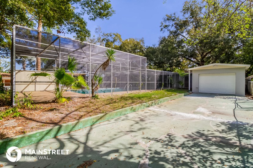 a house with a tennis court in front of a greenhouse