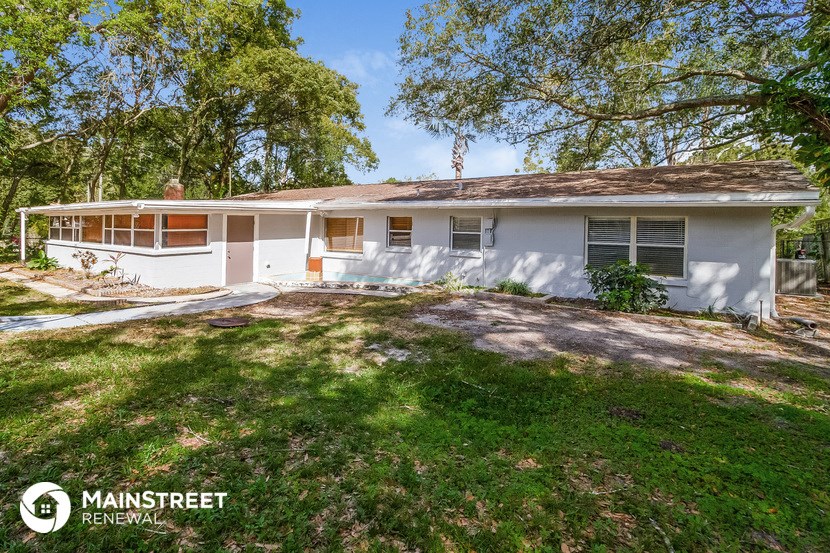 a white house with a lawn and trees