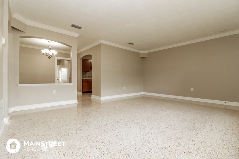 an empty living room with a white tile floor and gray walls