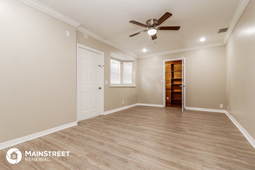 a living room with a ceiling fan and a door to a closet