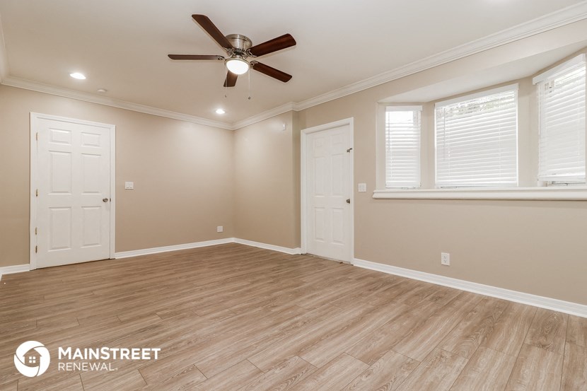 the master bedroom has a large window and a ceiling fan