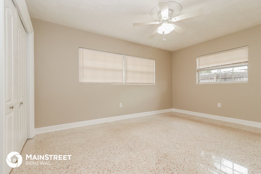 the master bedroom has a carpeted floor and a ceiling fan