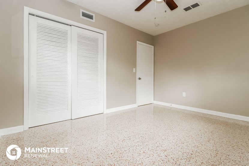 a empty room with two doors and a ceiling fan
