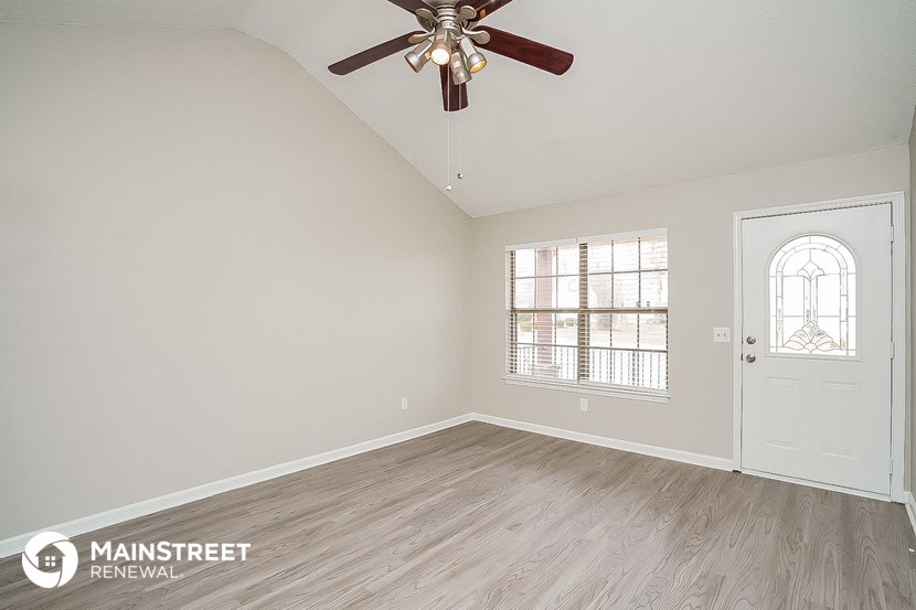 the master bedroom has a large window and a ceiling fan