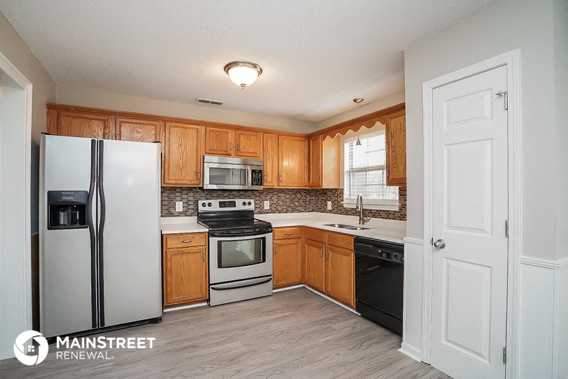 a kitchen with wooden cabinets and a white refrigerator