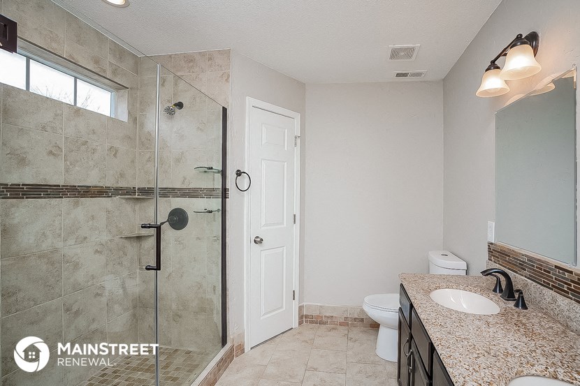 the master bathroom has a large walk in shower and a sink and a toilet