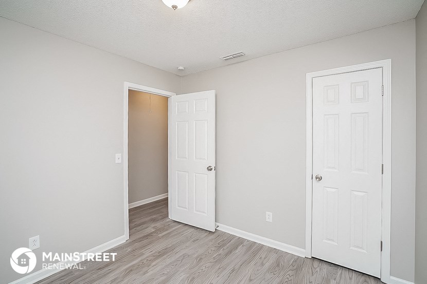 a bedroom with two doors and a door to a closet