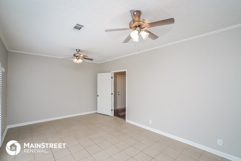 a living room with a ceiling fan and a tiled floor