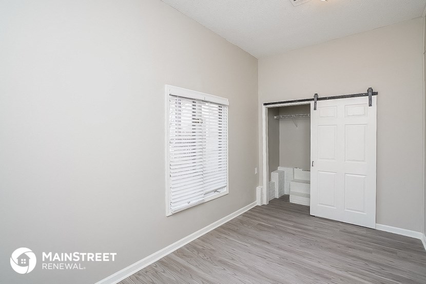 a bedroom with a closet and a door to a bathroom